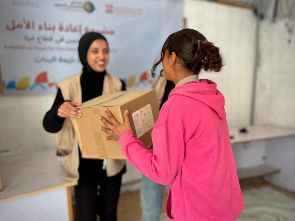 A girl receives an adolescent kit containing hygiene items. ©UNFPA/SDF.