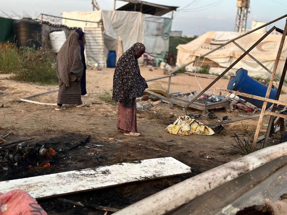 Women and girls walk around a destroyed displacement camp in Gaza. © UNFPA/Media Clinic.