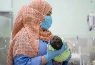 إحدى عاملات الرعاية الصحية تعتني بالأطفال المواليد في قسم حديثي الولادة الذي يدعمه صندوق الأمم المتحدة للسكان في مستشفى الشعب في