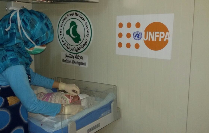 إحدى العاملات فى مجال الصحة تقوم بالكشف الدوري على طفل حديث الولادة فى غرفة الولادة  التابع لصندوق الأمم المتحدة للسكان في مخيم الحبانية، بمحافظة الأنبار، وسط العراق.
