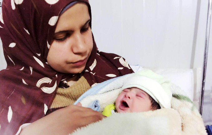 Kholoud Suliman holds her infant daughter, the 5000th baby born at a UNFPA-supported maternal clinic in Zaatari. © UNFPA Jordan - See more at: http://www.unfpa.org/news/5000th-baby-born-unfpa-supported-clinic-refugees-jordan#sthash.Lt1j8FIn.dpuf
