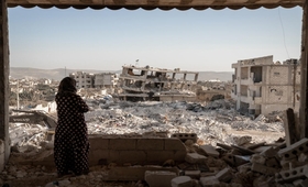 A woman looks over a scene of destruction following the earthquakes, Jinderis, Syria.  © UNFPA/Karam Al-Masri