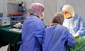  تجري ثلاث طبيبات توليد عملية جراحية في غرفة العمليات في مستشفى إدلب للولادة. ثلاثة عشر عاما من النزاع والنقص الحاد في التمويل ي
