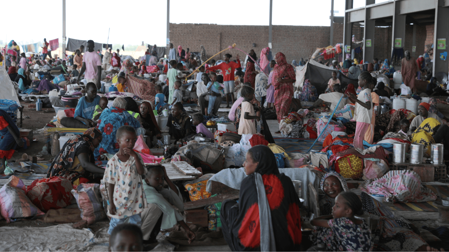 Crowded IDP shelter and temporary health clinic with many women and children.