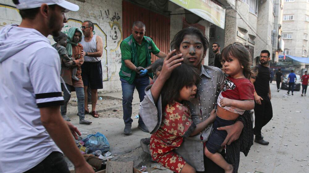 People flee during an Israeli airstrike in Gaza City. © Mohamed Zaanoun/Middle East Images/AFP via Getty Images