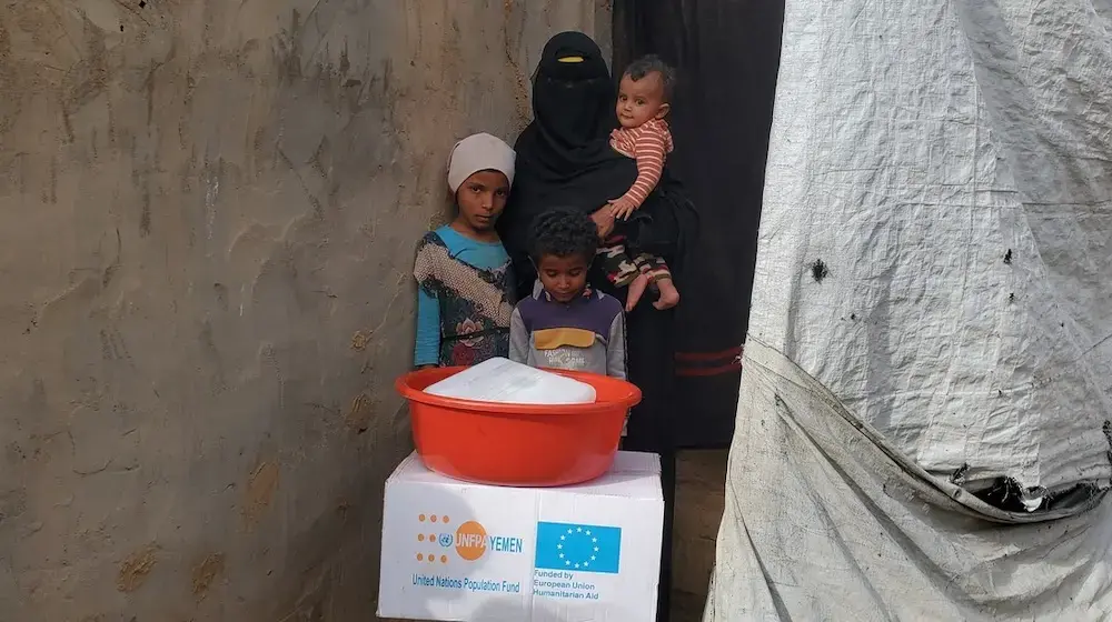 Amina with her children after receiving essential supplies to help the family get through the immediate post-crisis period. © Shadi Al-Saady/Yemen Development Foundation YDF