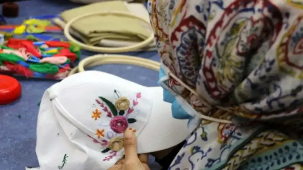 A survivor of gender-based violence takes part in an embroidery class as part of the life skills training programme at a UNFPA-s